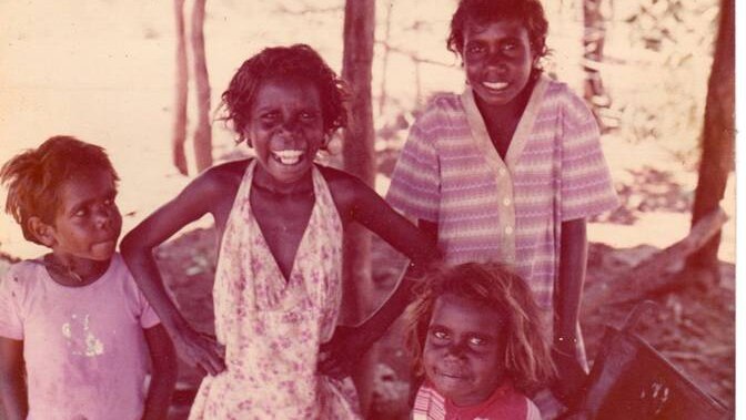 Four kids smile at the camera.