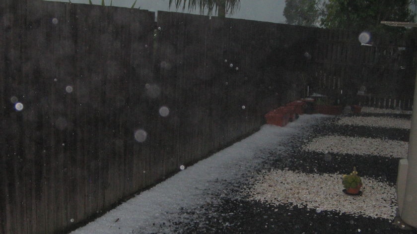 Hail piled up along the back fence of house at Redbank, north of Brisbane, at 4:30am AEST.