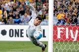 Socceroos keeper Mat Ryan dives at a ball that hit the post from a Syria free kick