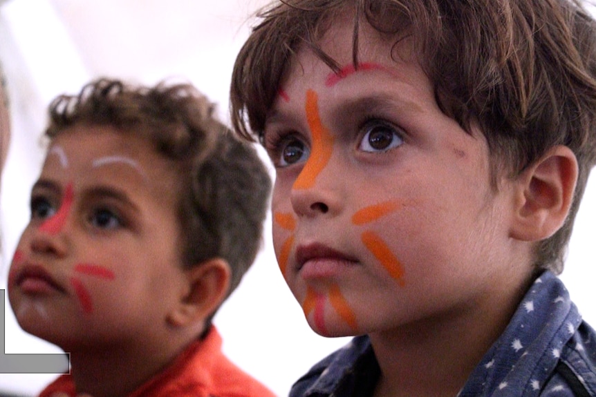 Children get their faces painted at a party in Debaga refugee camp.