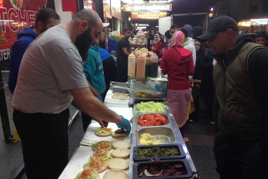 Stall holder Yasser Elyatim puts together camel burgers at the Ramadan food festival in Lakemba