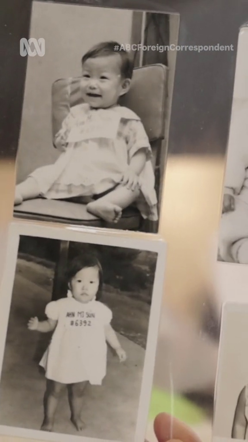 Two black and white photos show an Asian baby in a white dress or oversized t-shirt