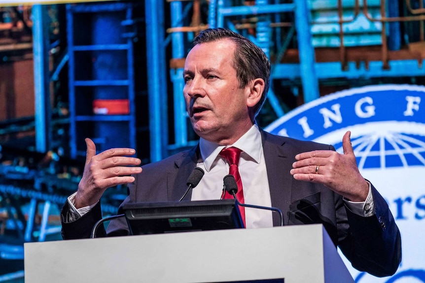 A man standing at a lectern, giving a presentation.