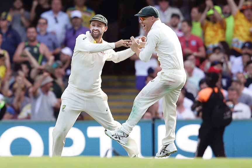 Nathan Lyon (L) and David Warner celebrate the wicket of James Vince.