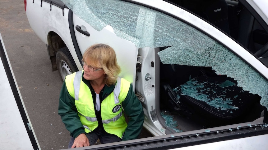 TAMS worker Jane Carder inspects a vandalised vehicle at depot in Holder.