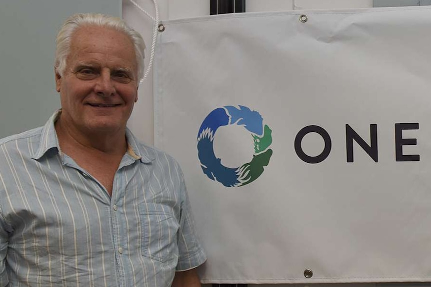 Man stands in front of a banner One Welfare