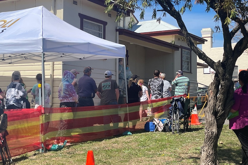 A group of people lining up to enter a vaccination hall