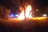 A car on fire at night.