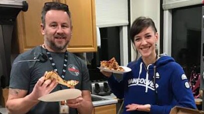 Two American air traffic controllers pose with pizza.