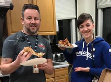 Two American air traffic controllers pose with pizza.