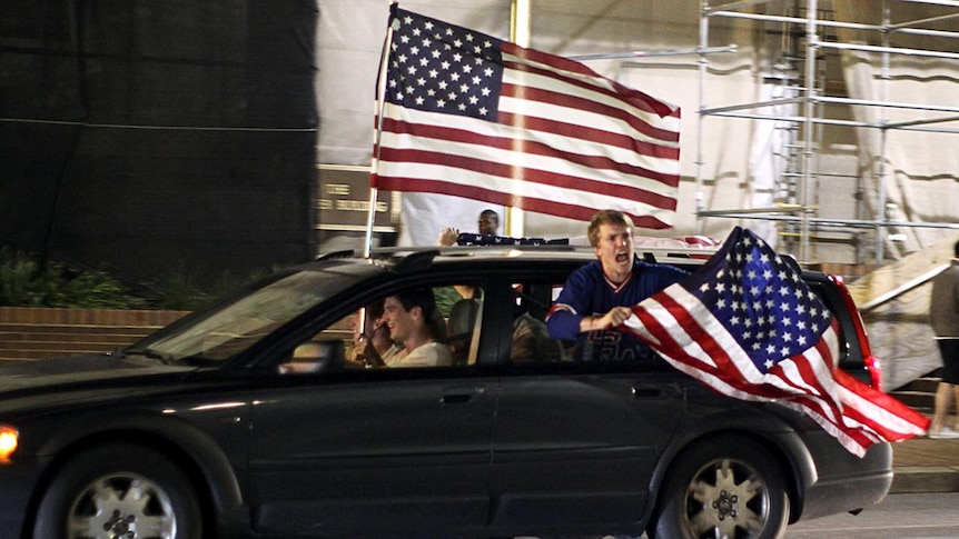 Revellers drive through the streets of Washington waving US flags (Reuters: Jason Reed)