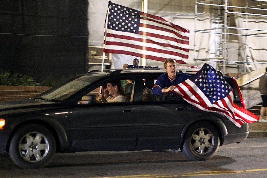 Revellers drive through the streets of Washington waving US flags (Reuters: Jason Reed)