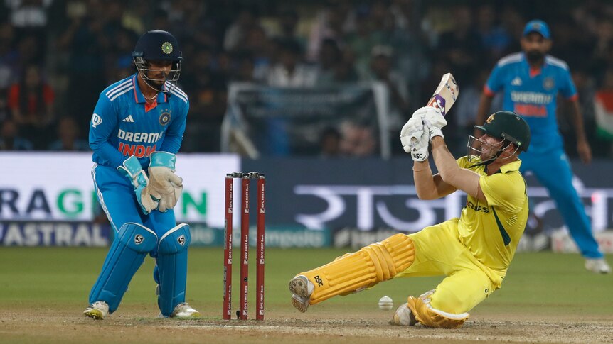 Australia batter David Warner falls as he is dismissed in an ODI against India.
