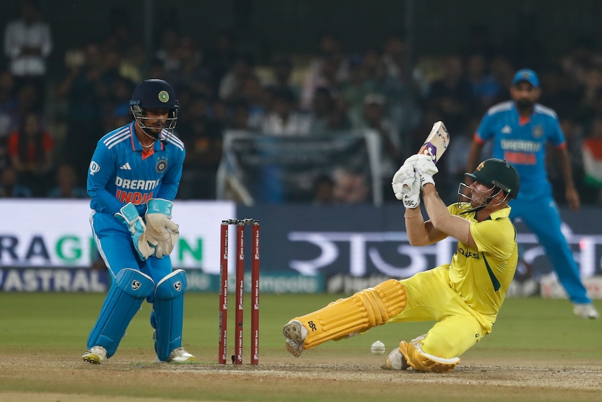 Australia batter David Warner falls as he is dismissed in an ODI against India.