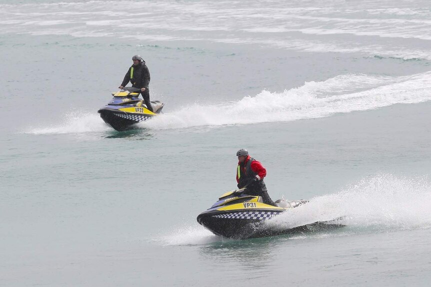 Police on jet skis search a beach near Anglesea in Victoria where human remains were found.