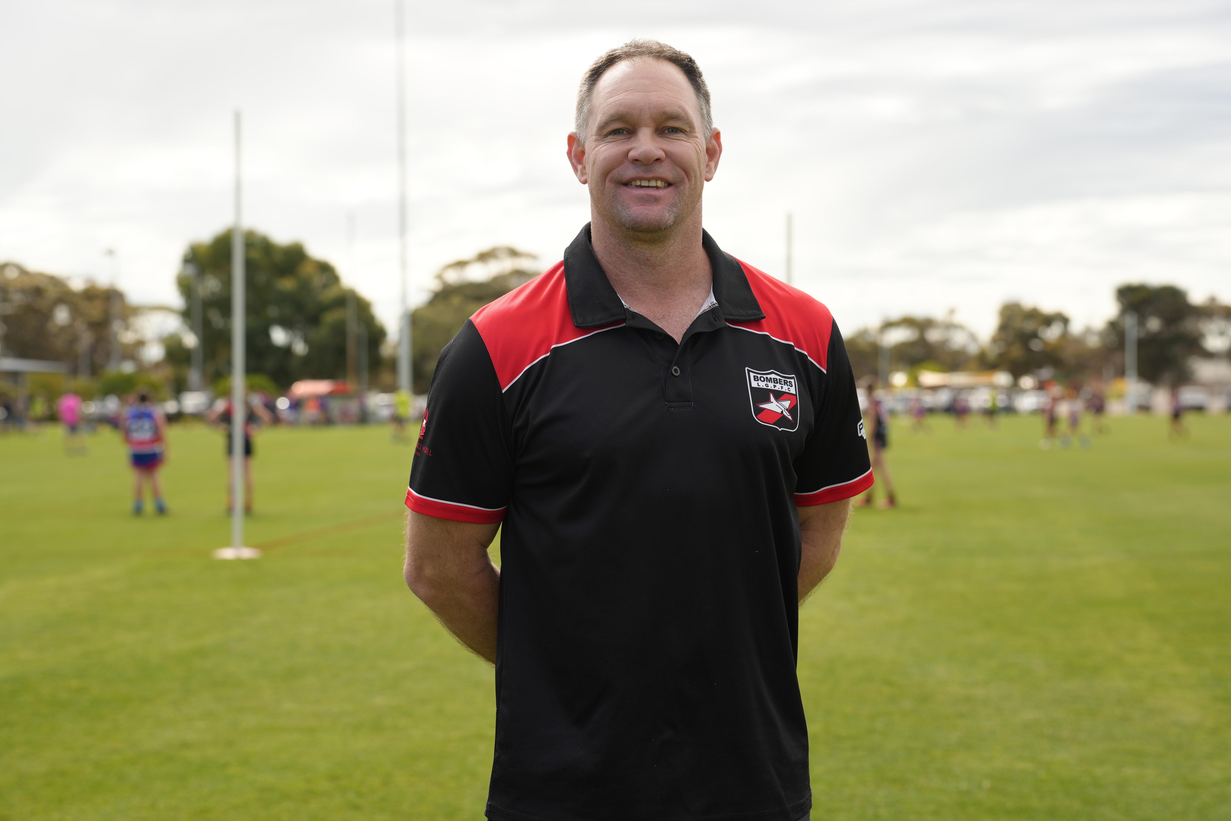 A man in a black and red polo shirt.