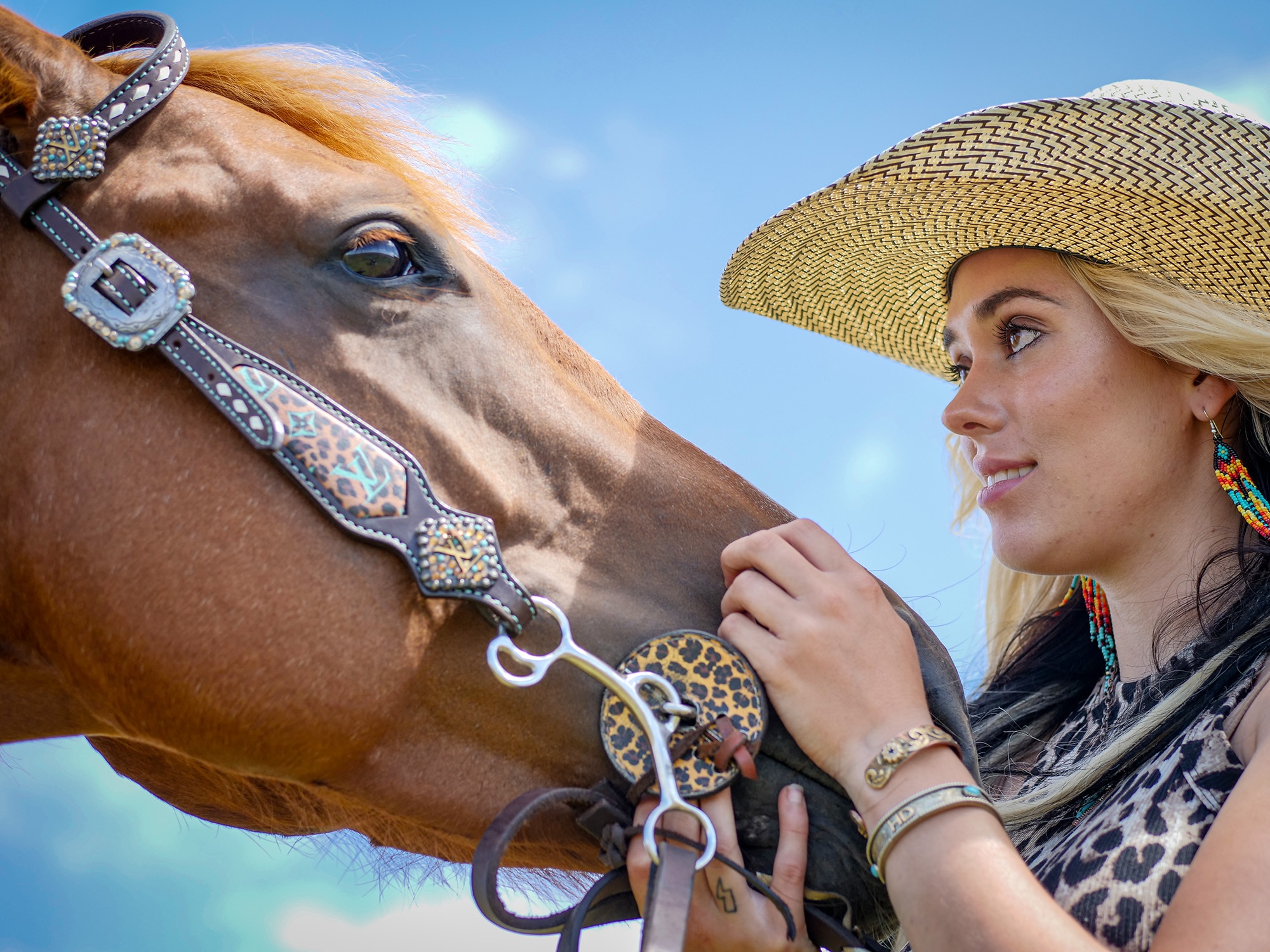 A woman scratches the nose of a chestnut horse