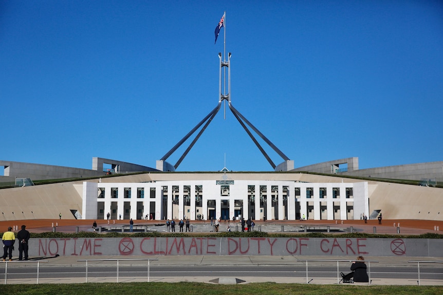 The words 'no time climate duty of care' spray painted outside Parliament House 