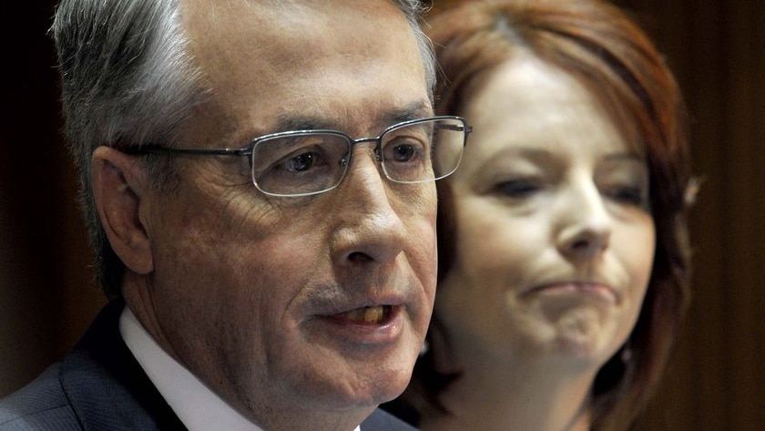 Prime Minister Julia Gillard, right, listens to Treasurer Wayne Swan speaking during a press conference (AAP: Alan Porritt)