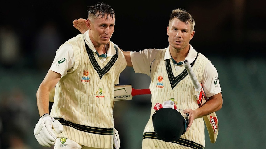 An Australian cricketer claps his batting partner on the back after a successful day's Test cricket.