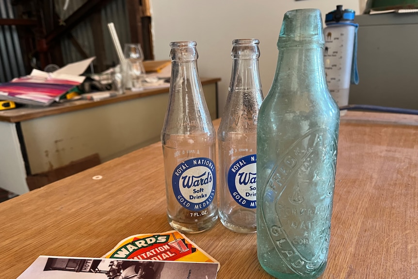Three old bottles sit on a desk