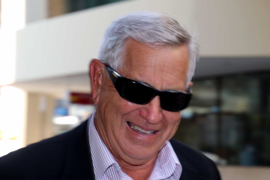 headshot of grey haired man in suit jacket and shirt.