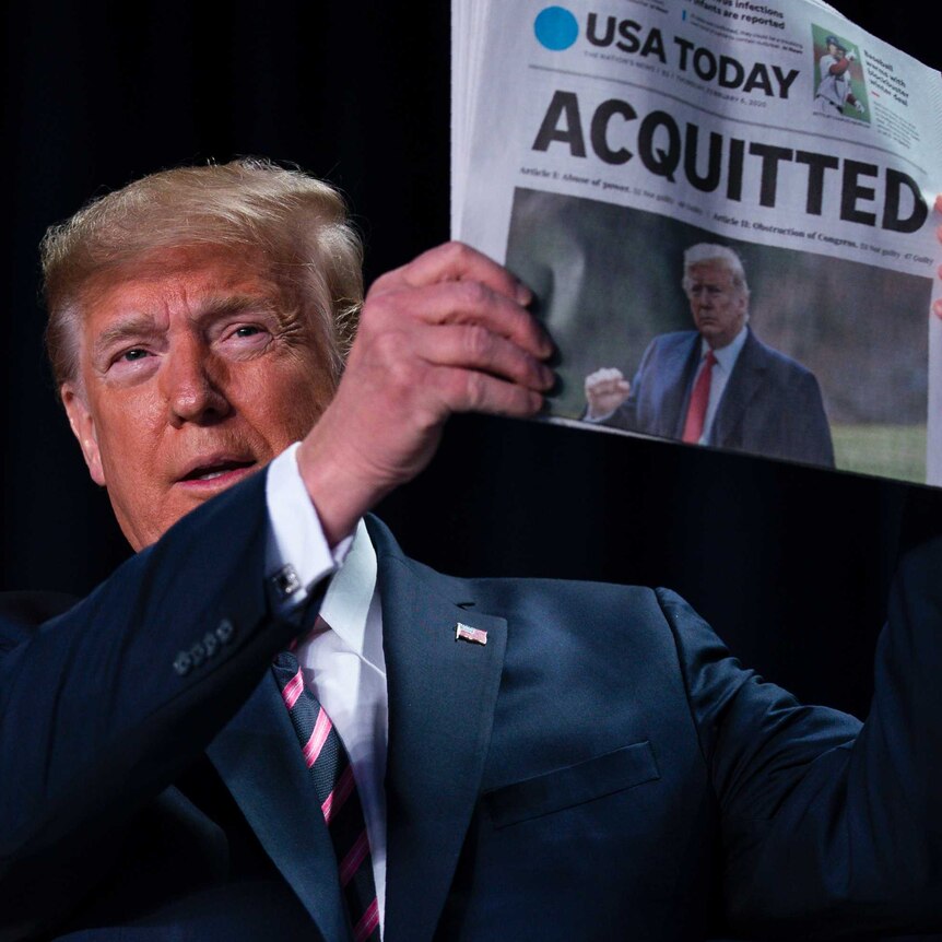 Trump stares straight at the camera holding a USA Today newspaper with the headline "ACQUITTED".