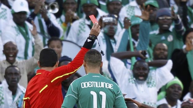 Nigeria's Sani Kaita is shown a red card by referee Oscar Ruiz.