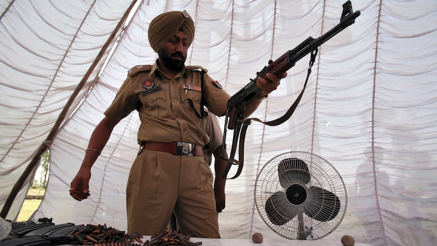 Punjab police officer with seized rifle