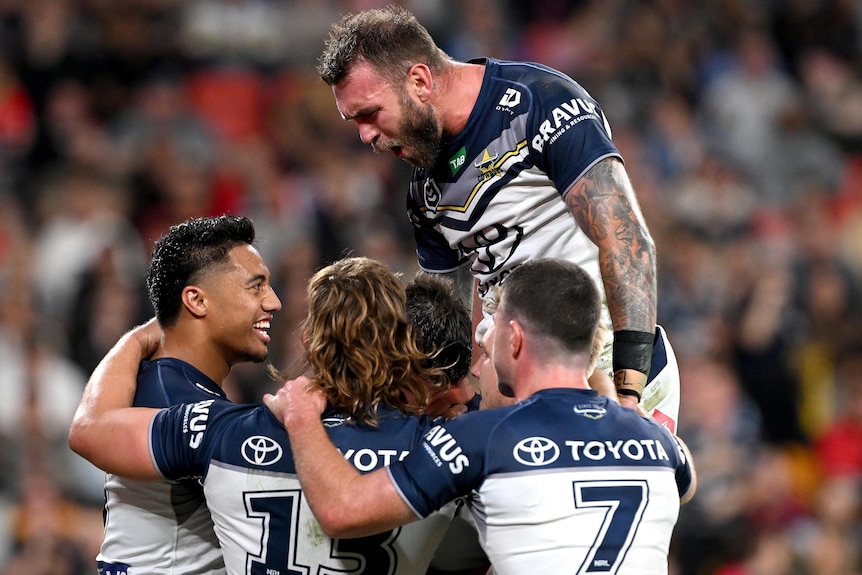North Queensland Cowboys NRL players embrace as they celebrate a try.