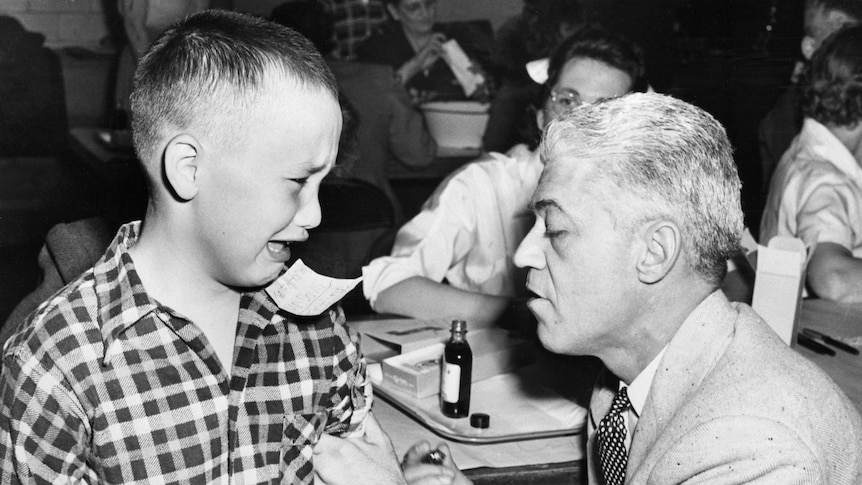 A boy being vaccinated cries