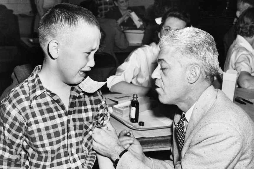 A boy being vaccinated cries