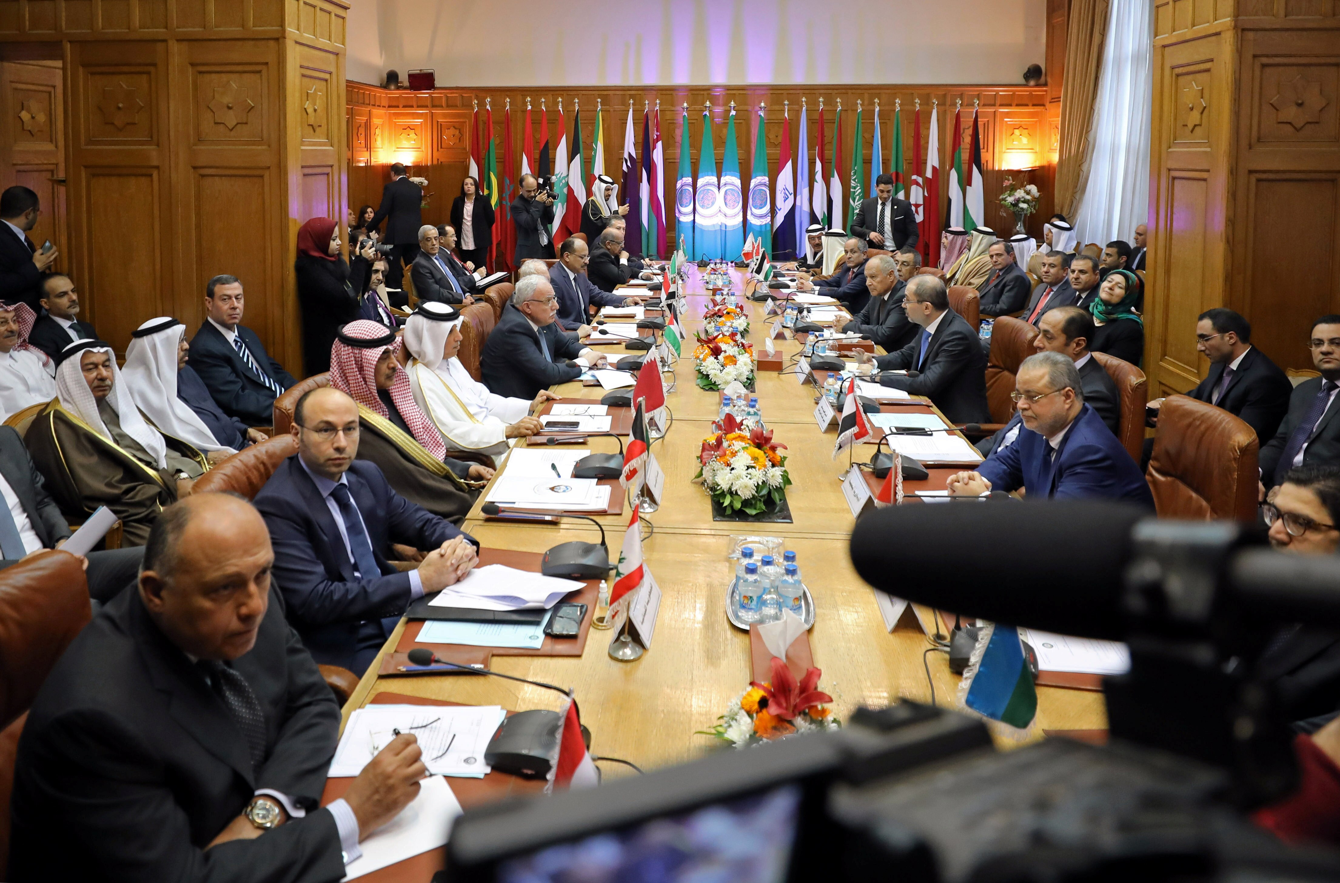 Arab ministers sit along both sides of a long formal meeting table ready for official talks.