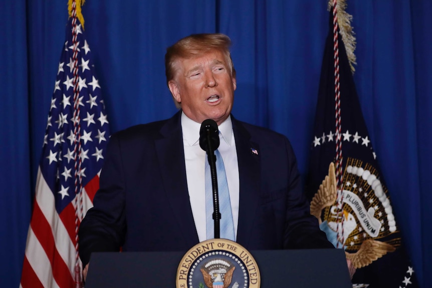 President Donald Trump at a stand giving a speech