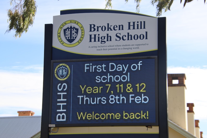 A sign reads, Broken Hill High School First Day of School. 