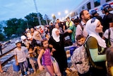 Asylum seekers try to enter a train at a train station