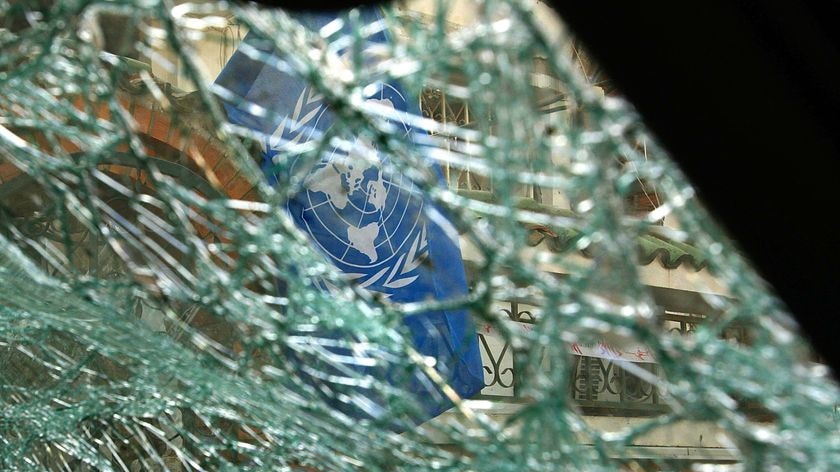 A UN flag hangs on the destroyed United Nations refugee agency