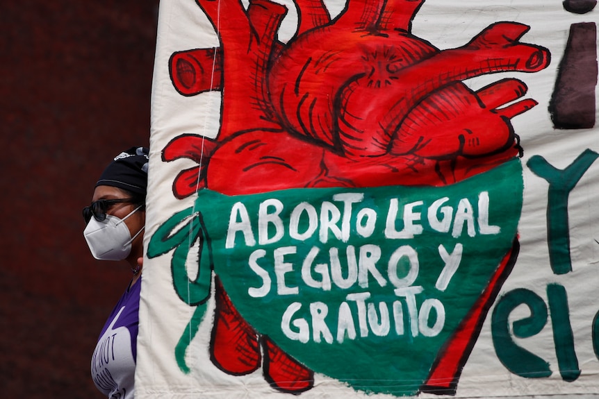 A sign with a heat which reads 'Aborto legal seguro y gratuito'.