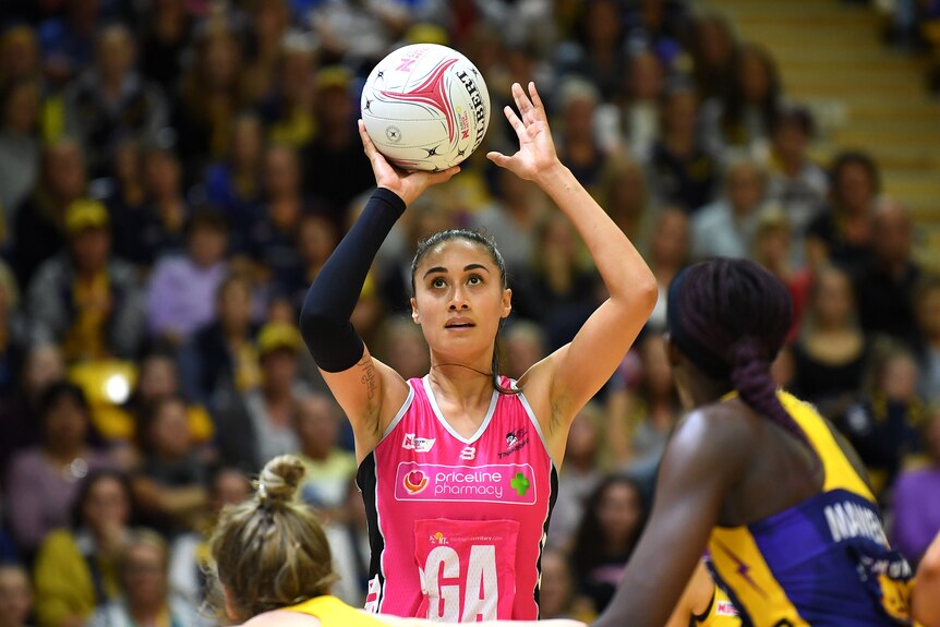 New Zealand shooter Maria Folau holds the ball overhead to shoot for the Adelaide Thunderbirds