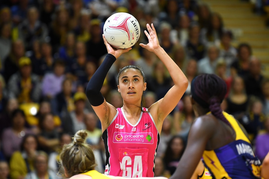 New Zealand shooter Maria Folau holds the ball overhead to shoot for the Adelaide Thunderbirds