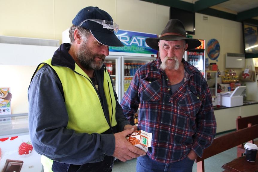 Mark Britton holds a Kiewa milk bottle as Jack Britton looks on