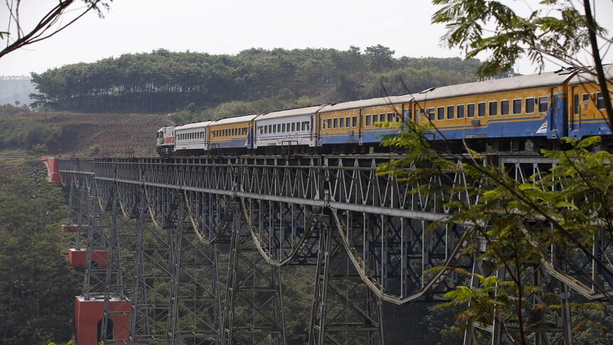 A passenger train crosses the Chikubang bridge as it travels from the city of Bandung to Jakarta