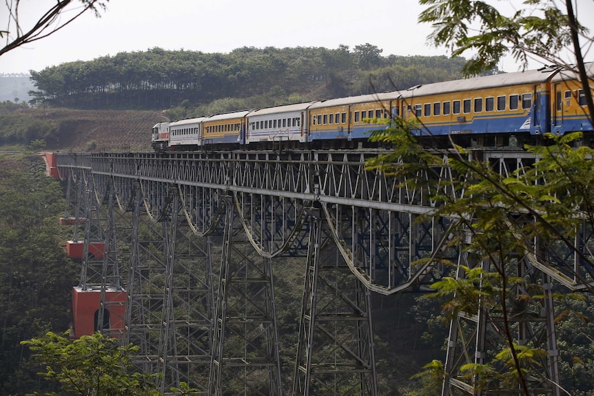 A passenger train crosses the Chikubang bridge as it travels from the city of Bandung to Jakarta