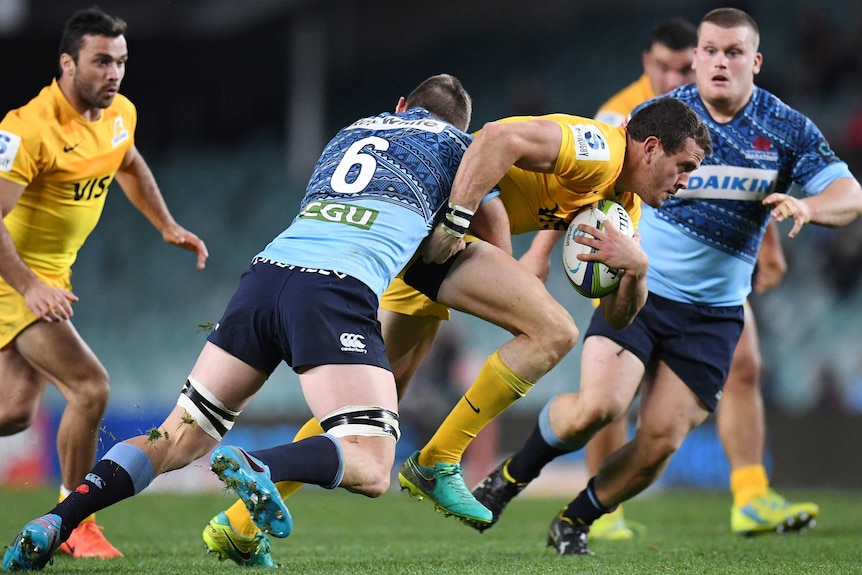 Jack Dempsey of the Waratahs tackles Emiliano Boffelli of the Jaguares