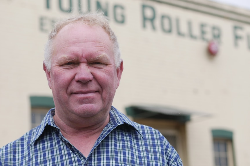 A man in front of a flour mill.