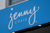A blue sign with white writing on a building that reads "Jenny Craig".