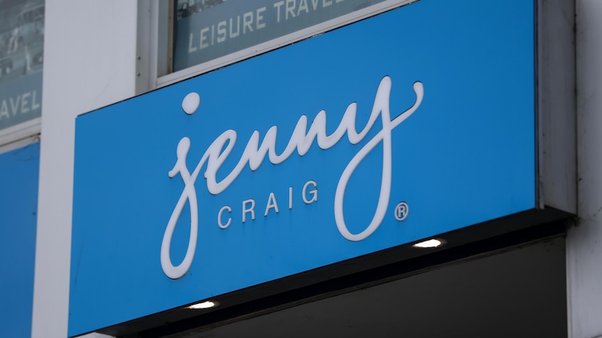 A blue sign with white writing on a building that reads "Jenny Craig".