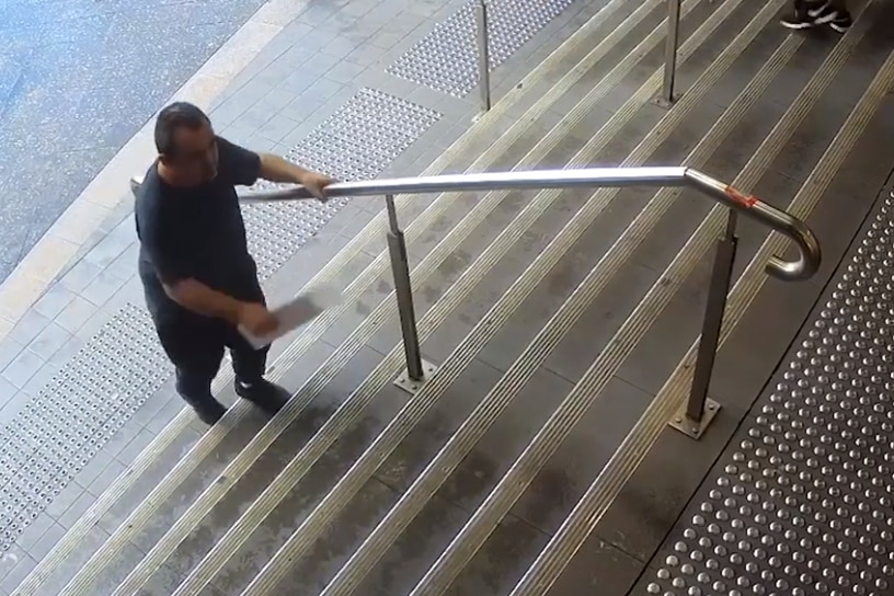 Man walks up stairs with piece of paper in hand