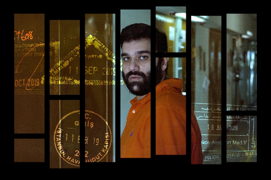 A man turns looking at the camera with a neutral expression. Behind him are cell doors. There are passport stamps on the image.