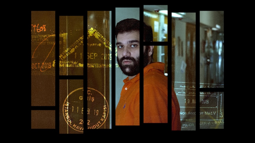 A man turns looking at the camera with a neutral expression. Behind him are cell doors. There are passport stamps on the image.